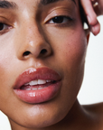 Soin des lèvres naturel et vegan Melayci, hydratant et glossy, porté par un modèle femme à la peau métissée.