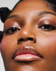 Soin des lèvres naturel et vegan Melayci, hydratant et glossy, porté par un modèle femme à la peau noire.