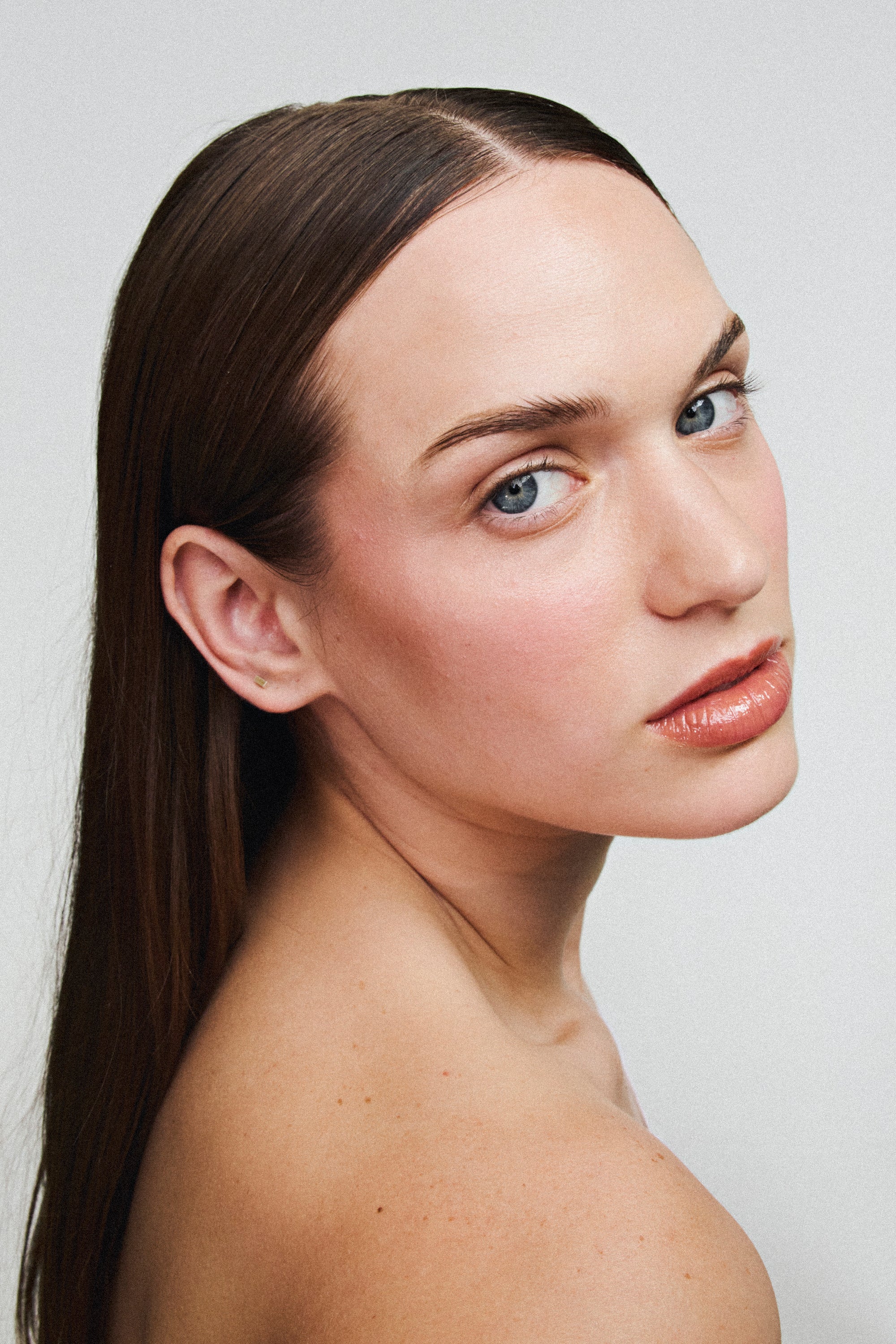 Application du gloss à lèvres eclat nourrissant Melayci teinte Peach sur une femme à la peau blanche.