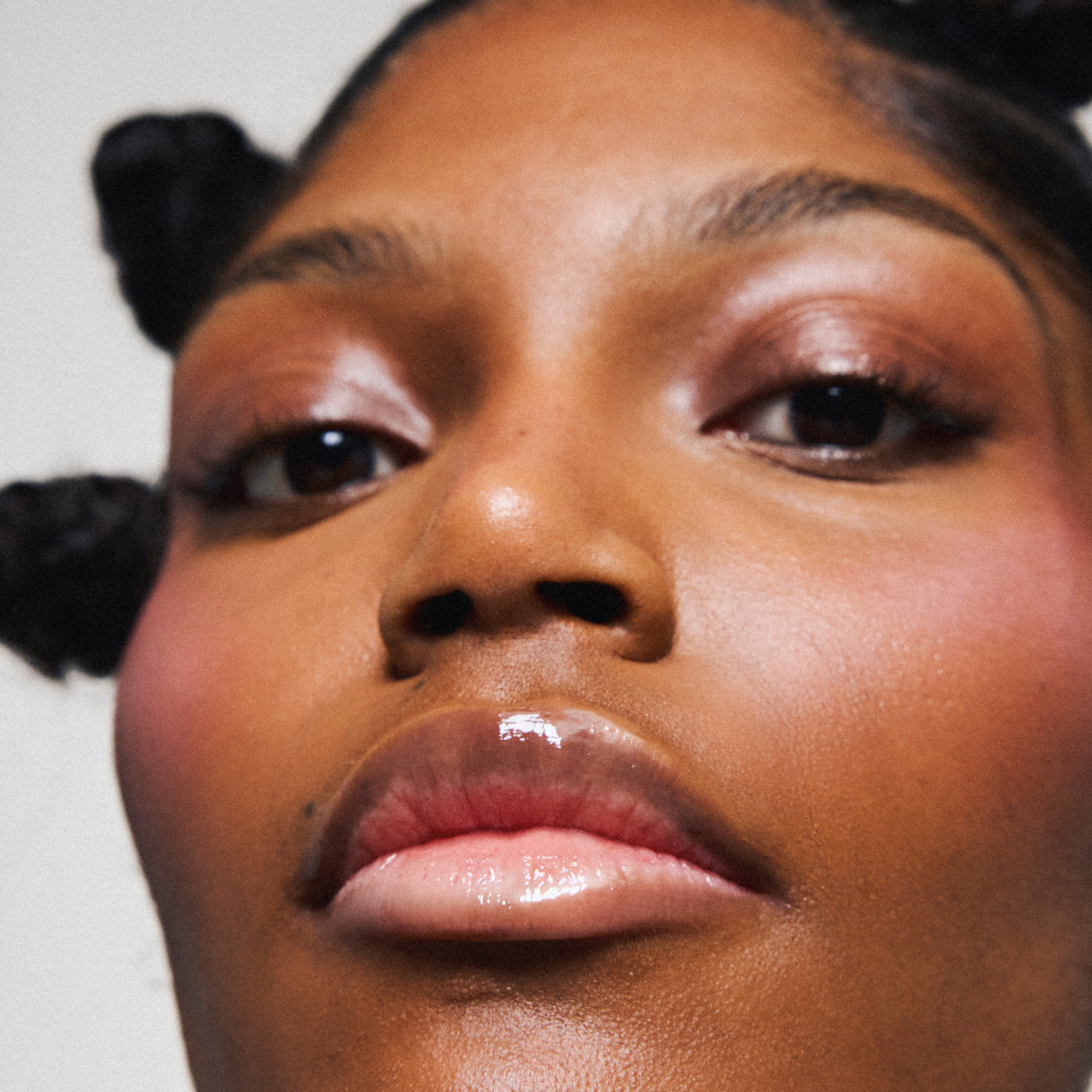 Soin des lèvres naturel et vegan Melayci, hydratant et glossy, porté par un modèle femme à la peau noire.